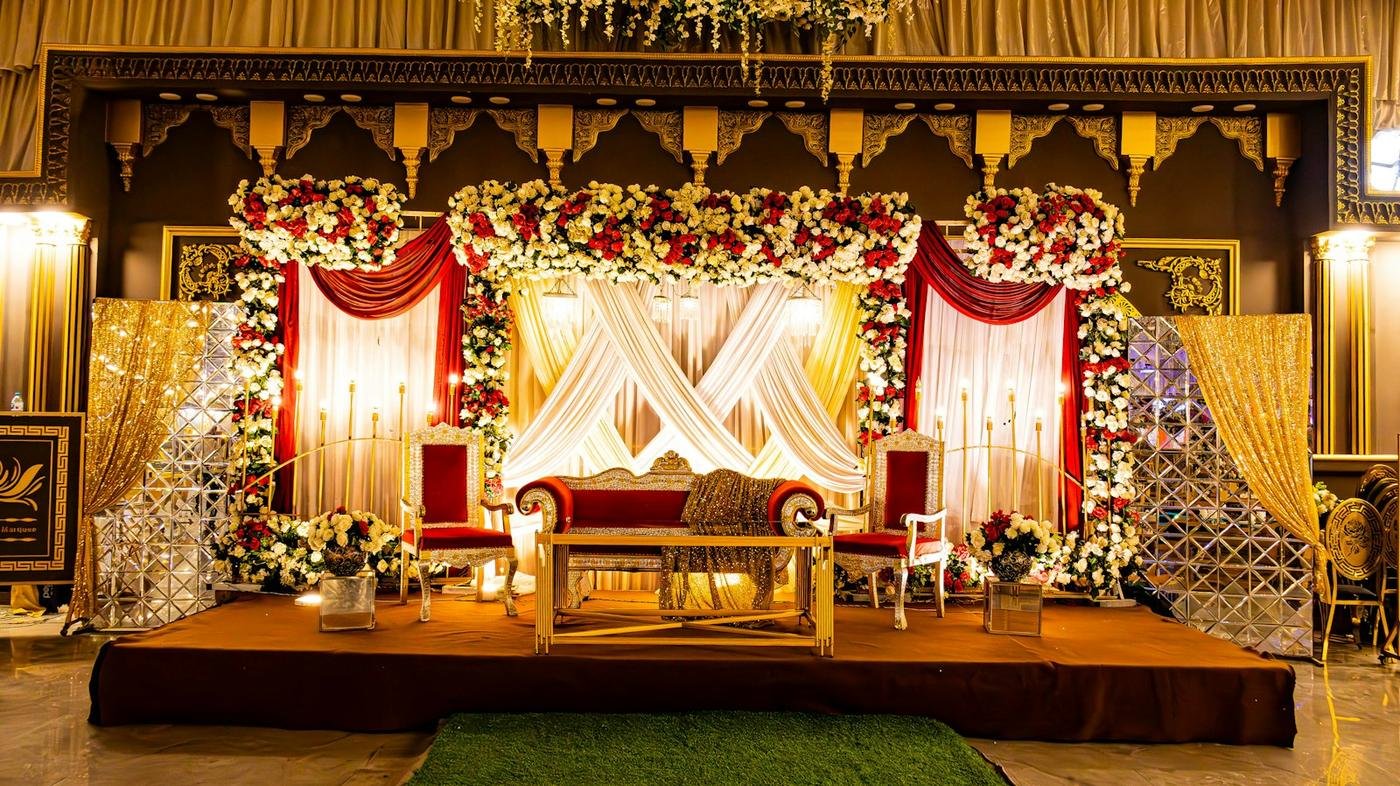 Red and gold wedding stage with a floral backdrop